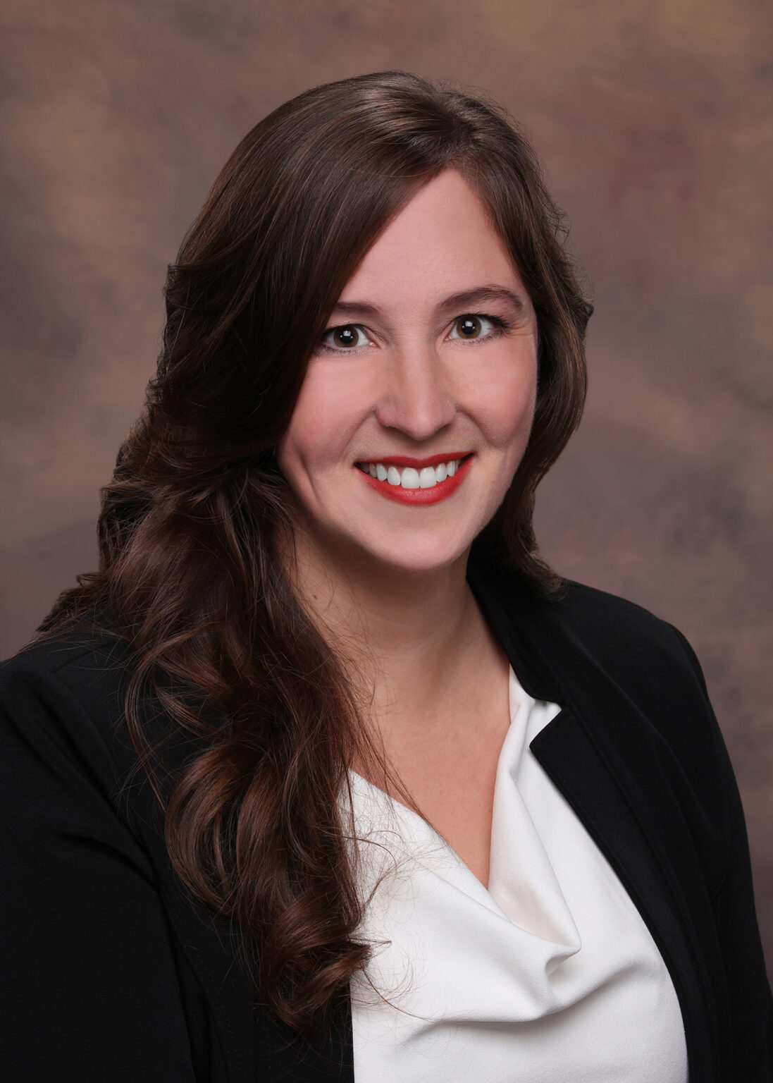 Alyssa Enzor Baxley, an uncontested divorce attorney at Baxley Maniscalco, LLP, poses for a picture in a black blazer and white blouse.