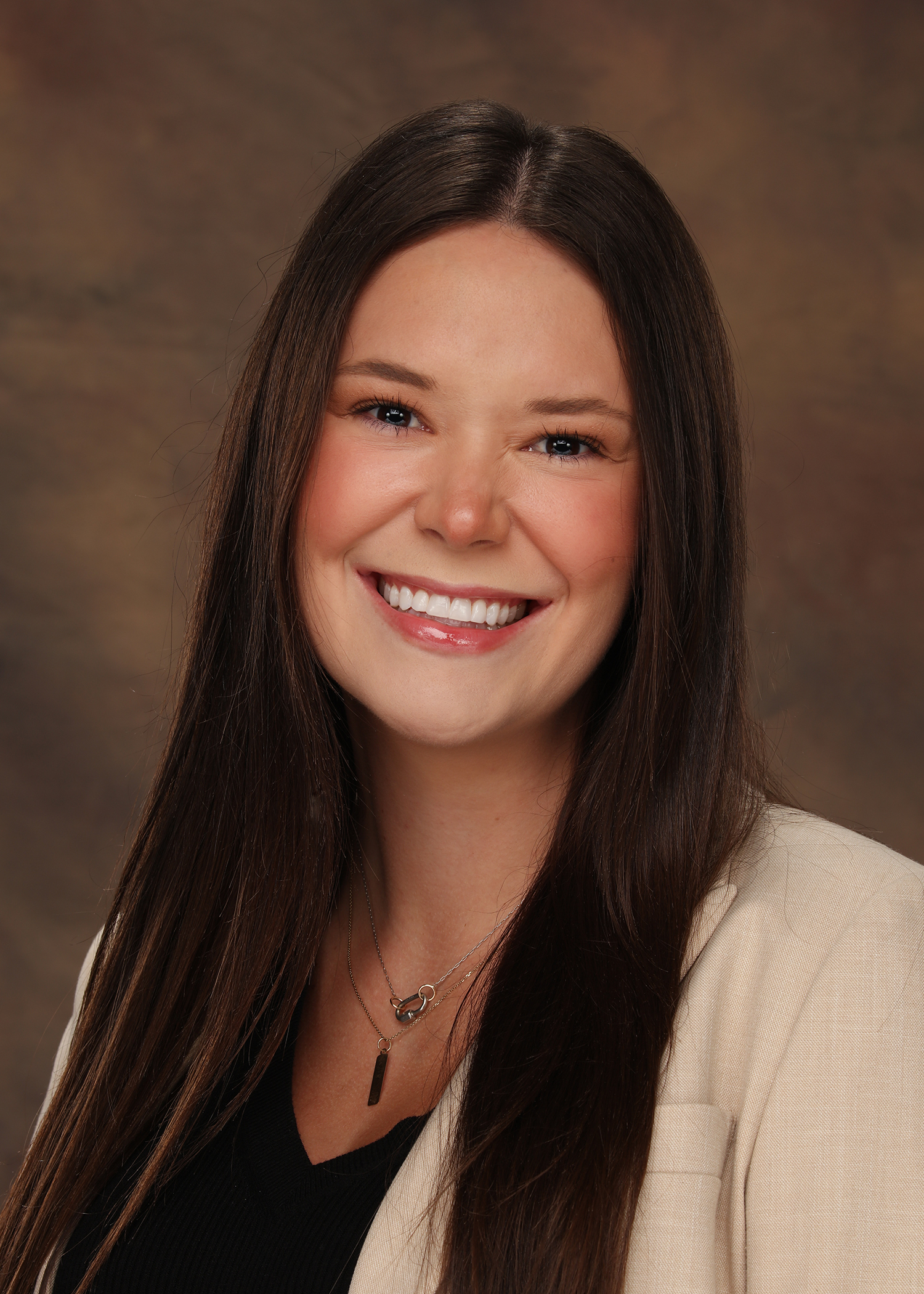 Sydney Merrin, a family law attorney with Baxley Maniscalco, poses for a picture in a beige top and black blouse.