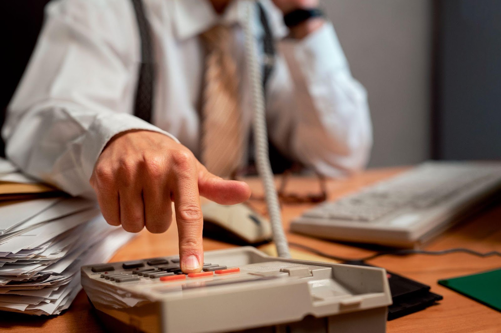 Worker at a desk using a calculator and reviewing documents, determining workers' compensation benefits.