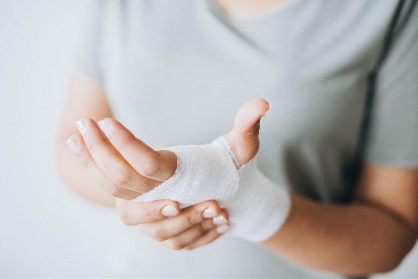 Close-up of a bandaged hand with visible dog bite wounds, showcasing the severity of potential injuries from dog attacks.