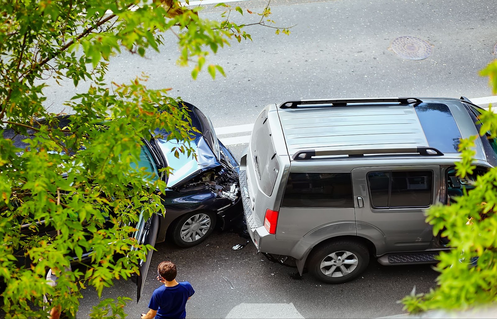 Two cars involved in a rear-end collision on a street.