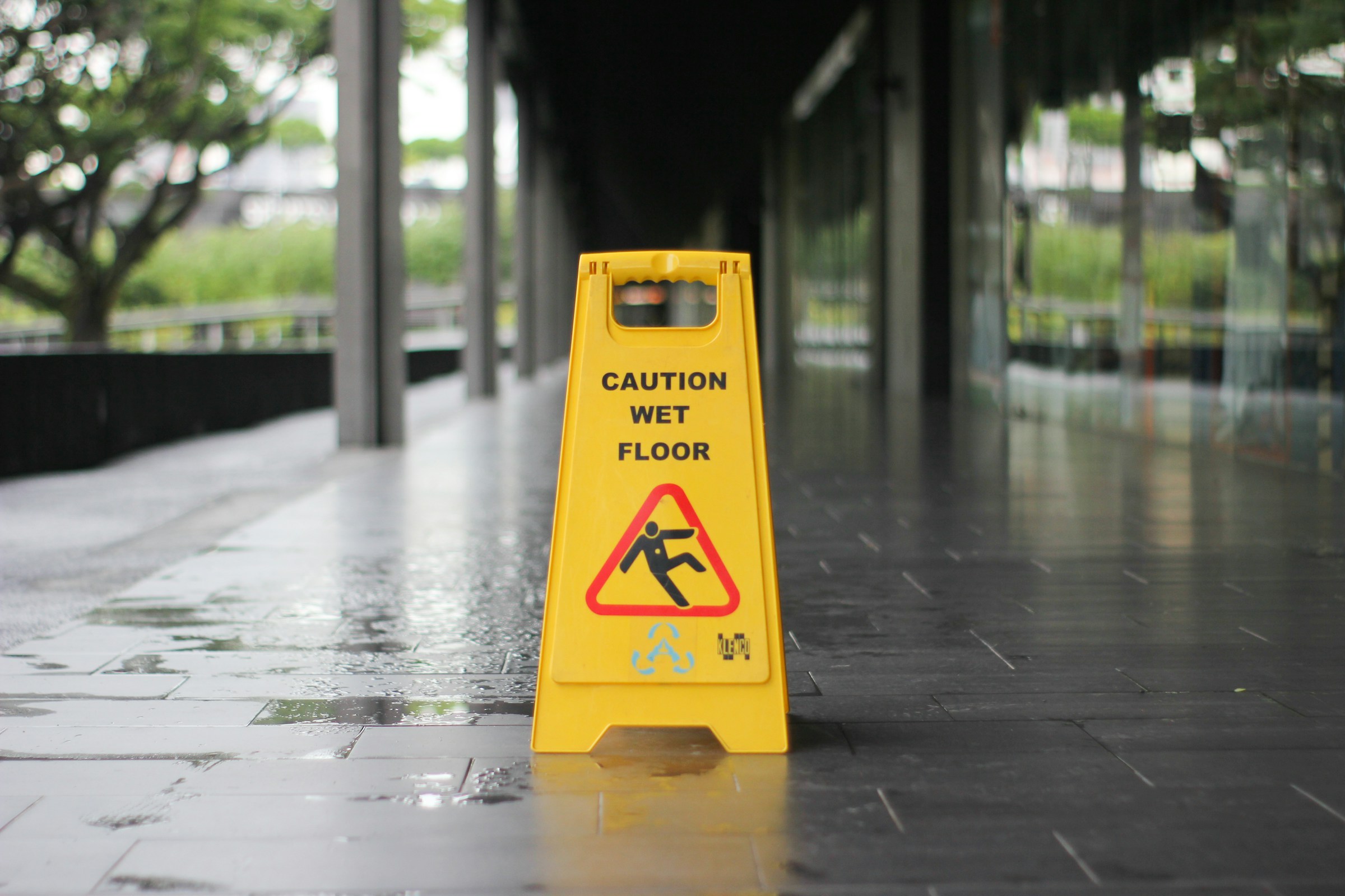 A yellow "Caution: Wet Floor" sign sits outside of a business in Alabama.