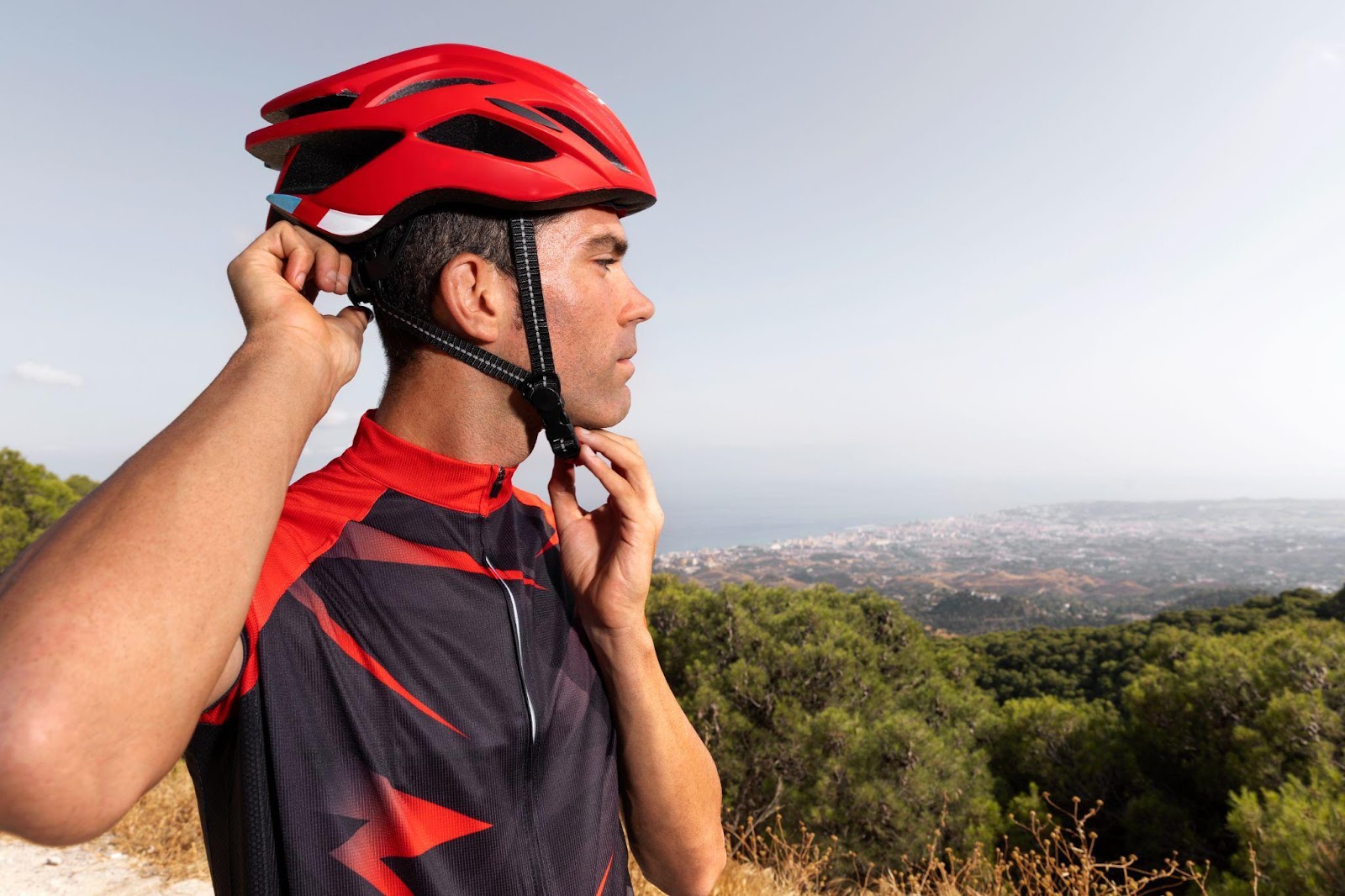 A biker putting on his helmet, preparing for a ride. The image highlights the importance of safety and protective gear for bicycle riders.