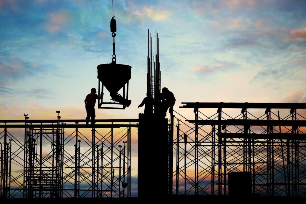 Construction workers are on scaffolding at a building site, performing tasks at various heights. The image highlights the potential dangers of scaffolding falls, a common cause of construction accidents, with safety equipment in use but risks still present.