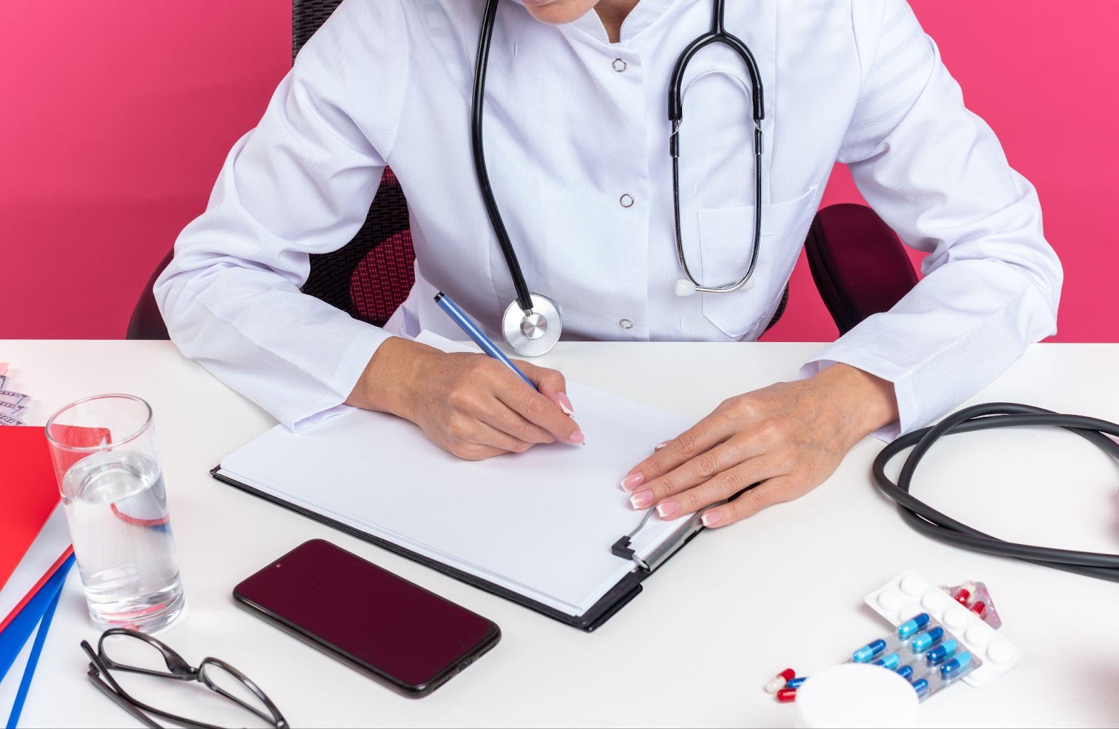 A doctor is writing notes on a clipboard, with a focused expression, symbolizing medical documentation. The image hints at the importance of accuracy in patient records, a key factor in preventing medical malpractice incidents.