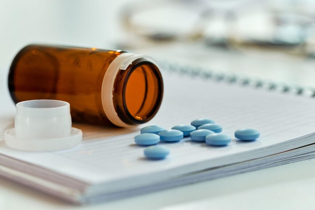 A close-up of several pills scattered over a prescription paper.