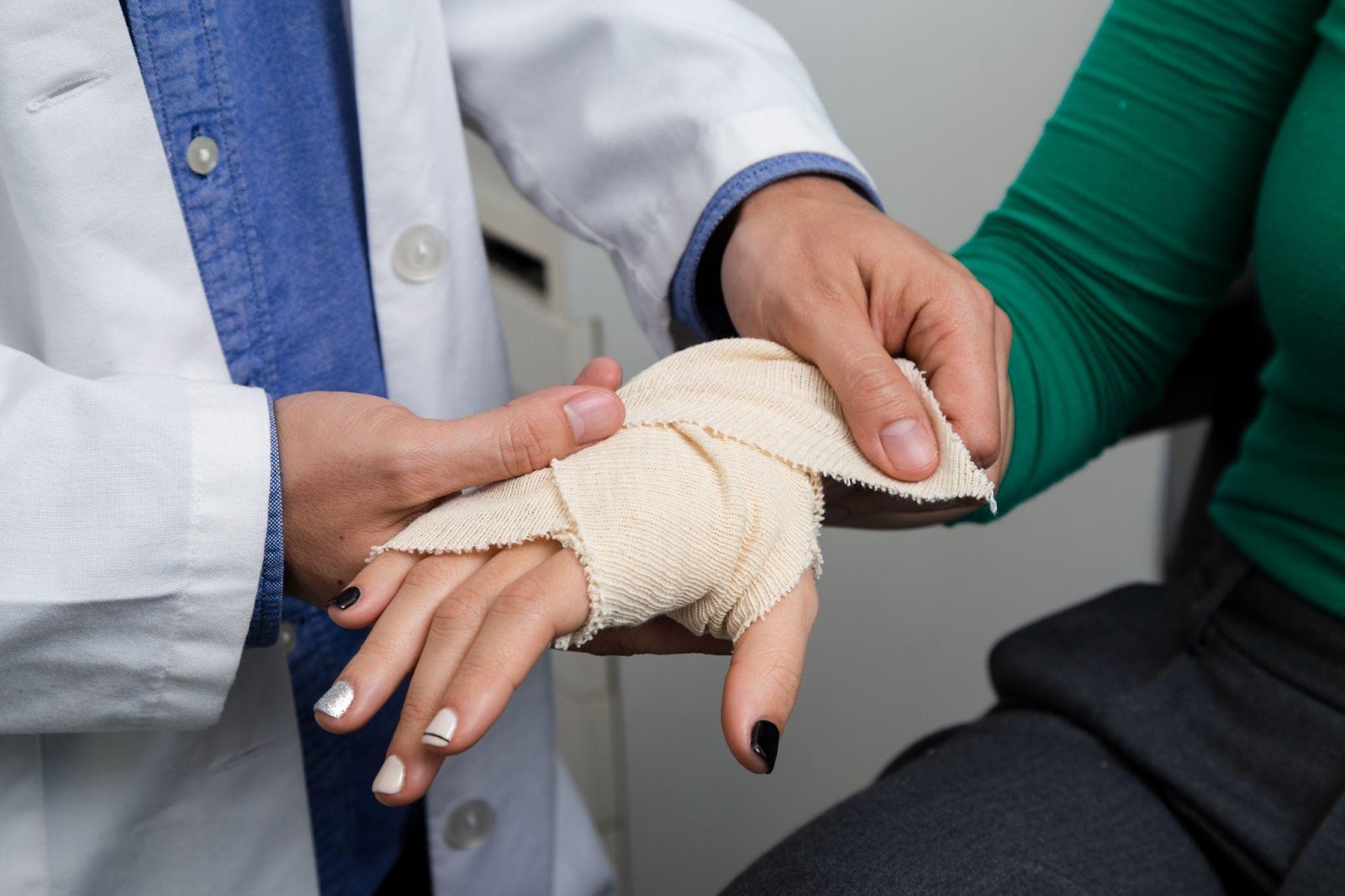 Hand receiving medical treatment with a bandage being applied, illustrating personal injury care; related to subrogation liens and medical expense recovery.