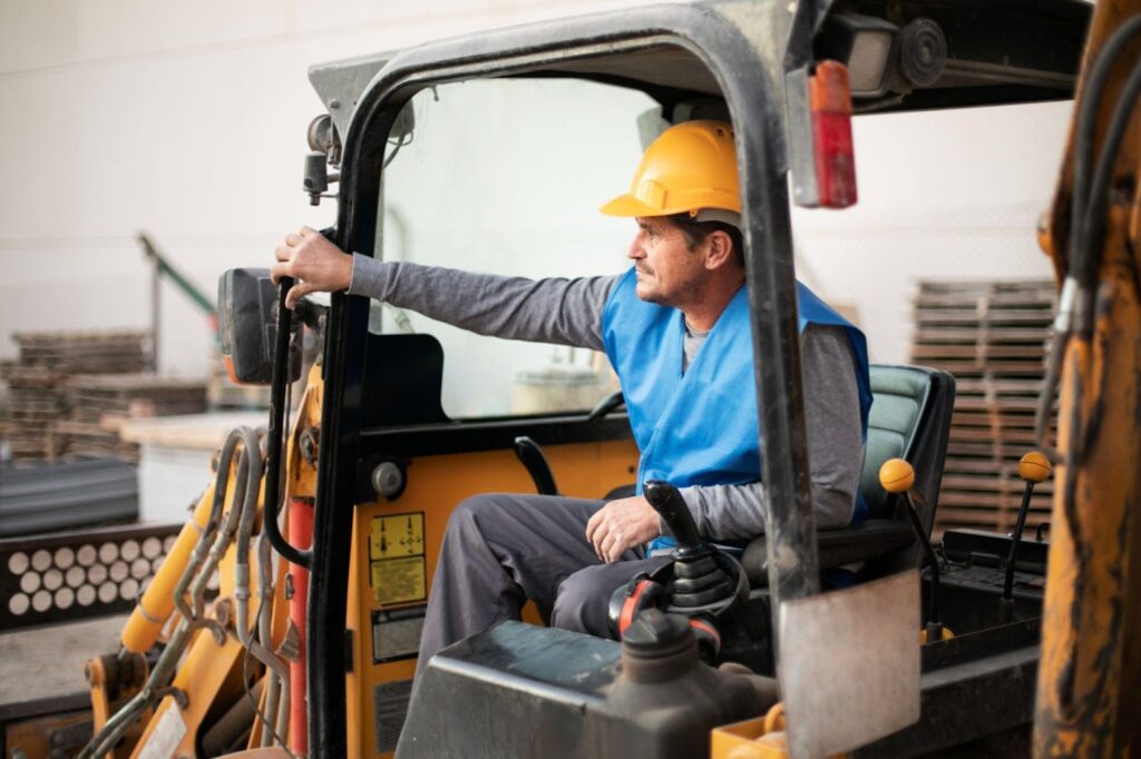 Construction worker operating a large yellow clark on a storage, focusing intently on the task.