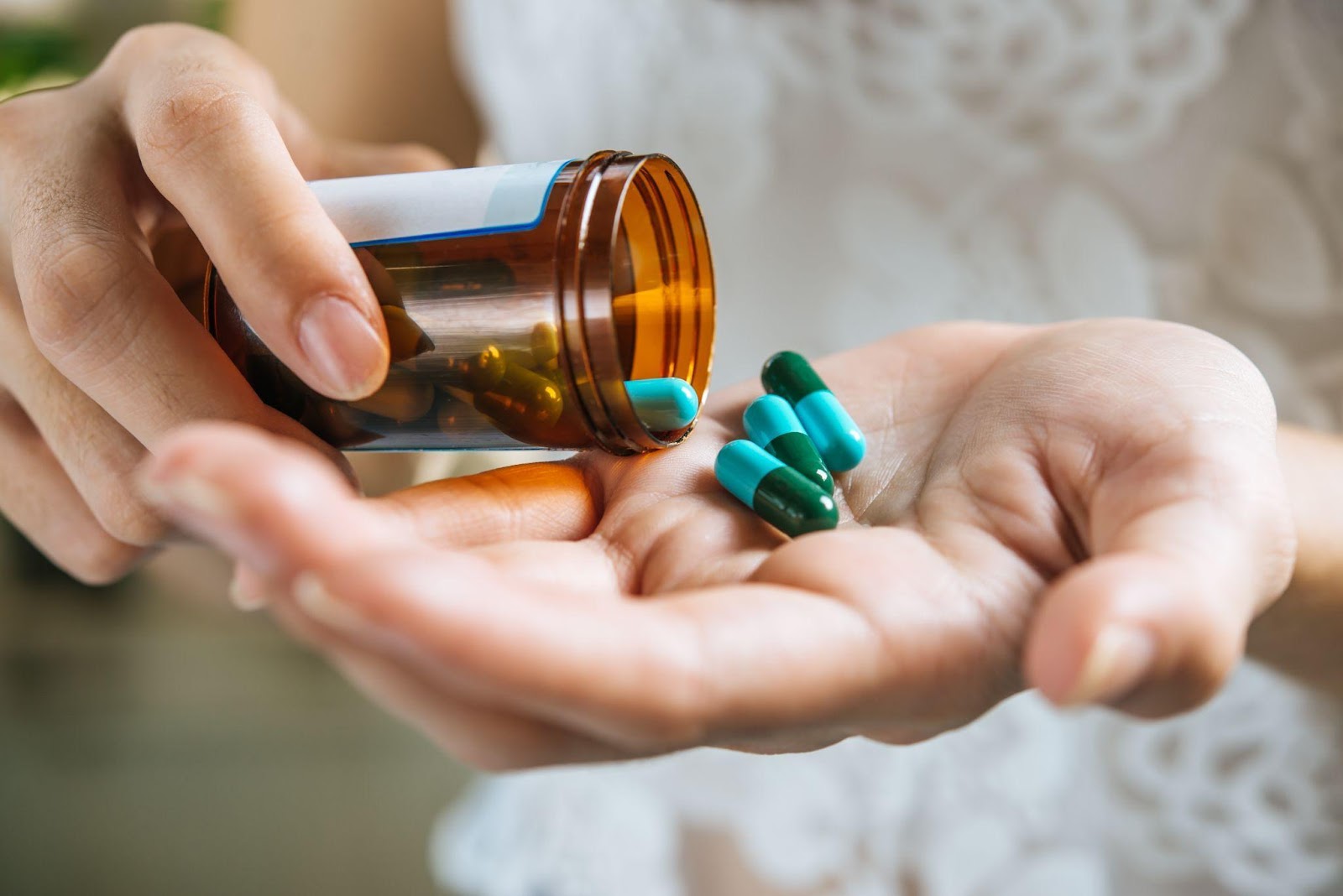 Close-up of a hand holding various medication pills, symbolizing concerns about dangerous drugs and the importance of awareness around drug recalls for consumer safety.