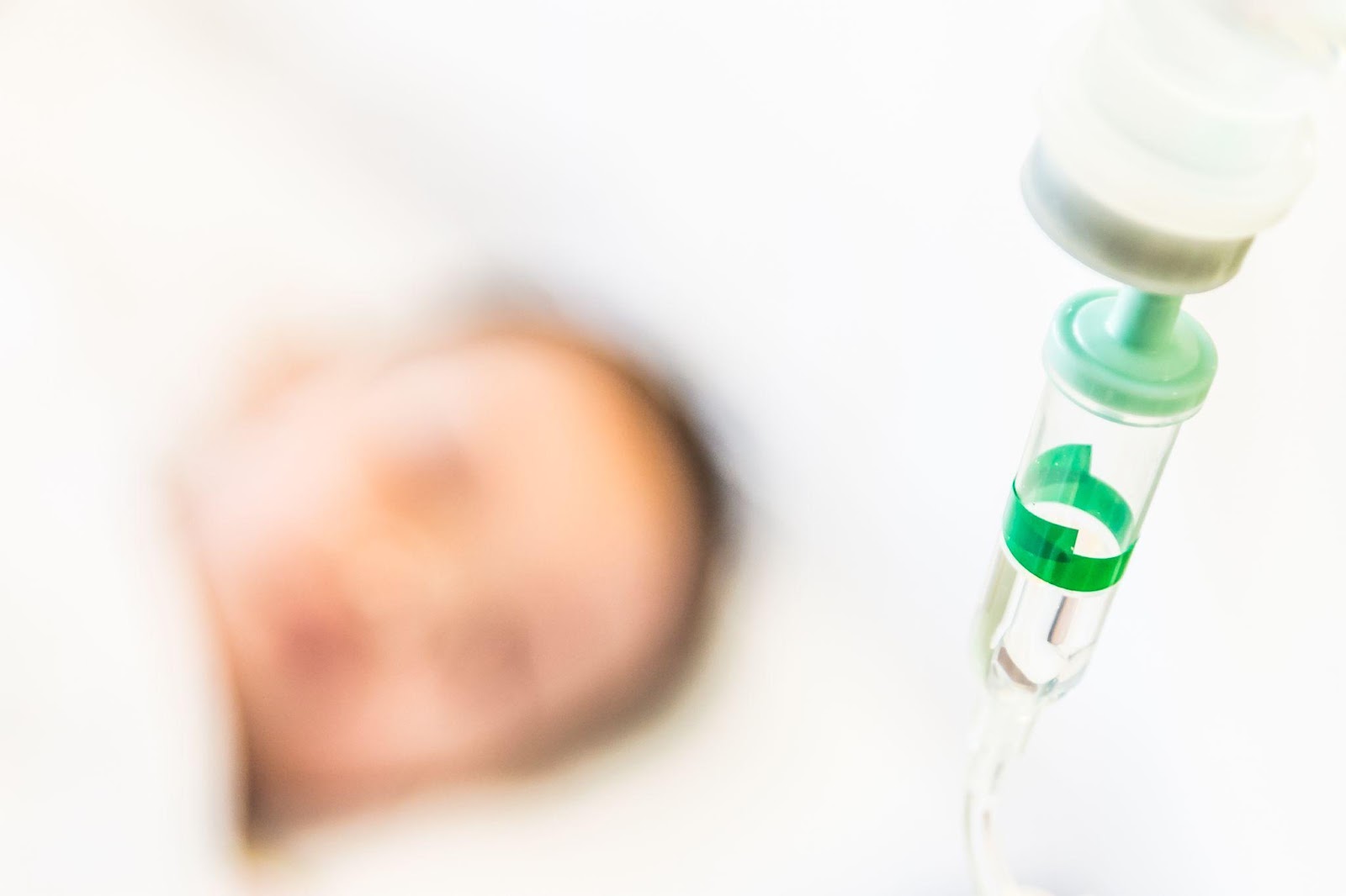 A newborn baby lies in a hospital bassinet, with medical equipment visible in the background. The image highlights concerns surrounding birth injuries and the potential for medical malpractice in neonatal care.