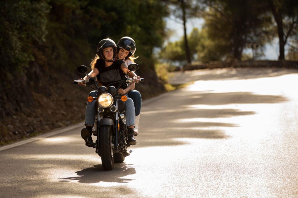 A motorcycle with two riders traveling on a scenic road, highlighting the potential for passenger injuries and the complexities of liability in motorcycle accidents.