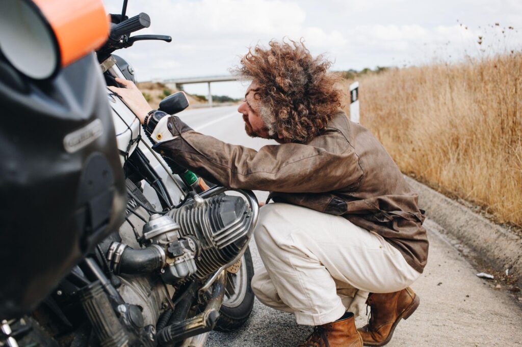 A person closely inspecting a motorcycle, emphasizing the process of assessing bike damage and pursuing compensation after a motorcycle accident.