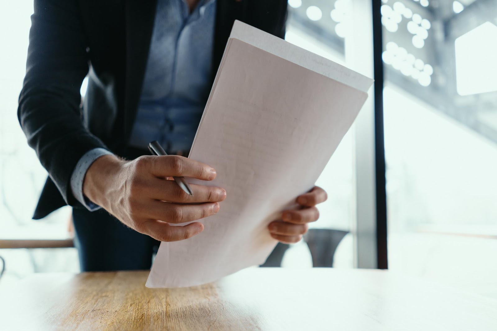 Close-up of a professional holding a document and pen, symbolizing the appeals process, including valid grounds for appeals and procedures followed in appellate courts.