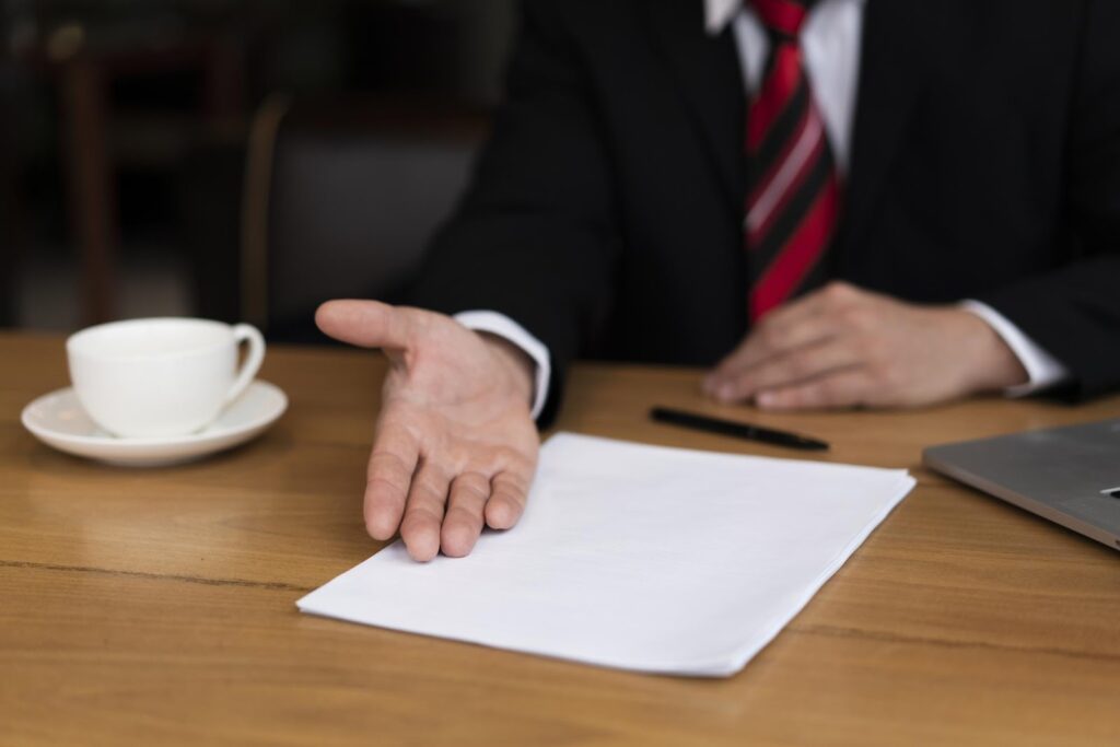 Close-up of a professional gesturing towards a document on a desk, representing the appeals process and the pursuit of appellate relief for court decisions deemed unfair.