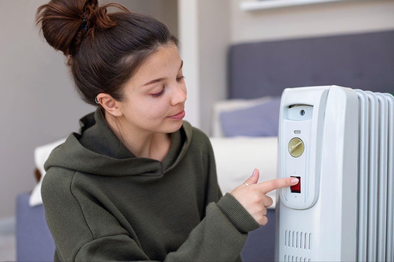 A woman adjusting a heater device, symbolizing the importance of proper maintenance. This image relates to carbon monoxide poisoning, highlighting the liability of property owners and landlords in ensuring the safety of tenants by maintaining appliances and ventilation systems.