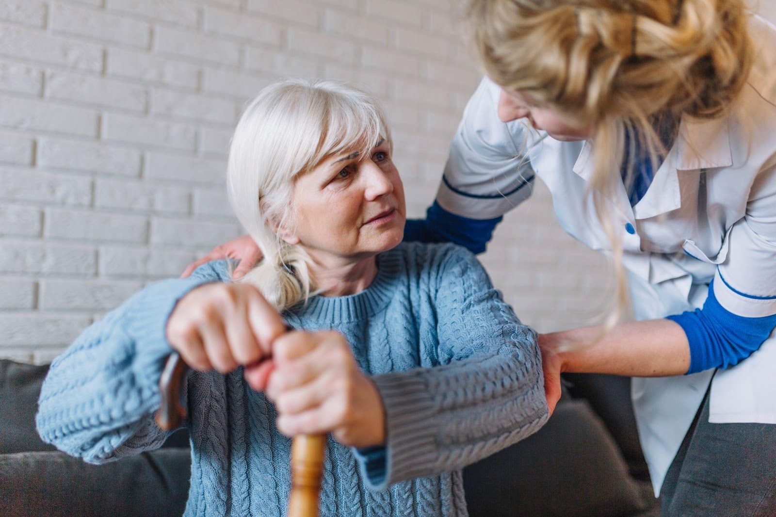 A caregiver assisting an elderly woman, highlighting concerns about elder abuse, including nursing home neglect and financial exploitation, which are serious issues affecting vulnerable seniors in Alabama.