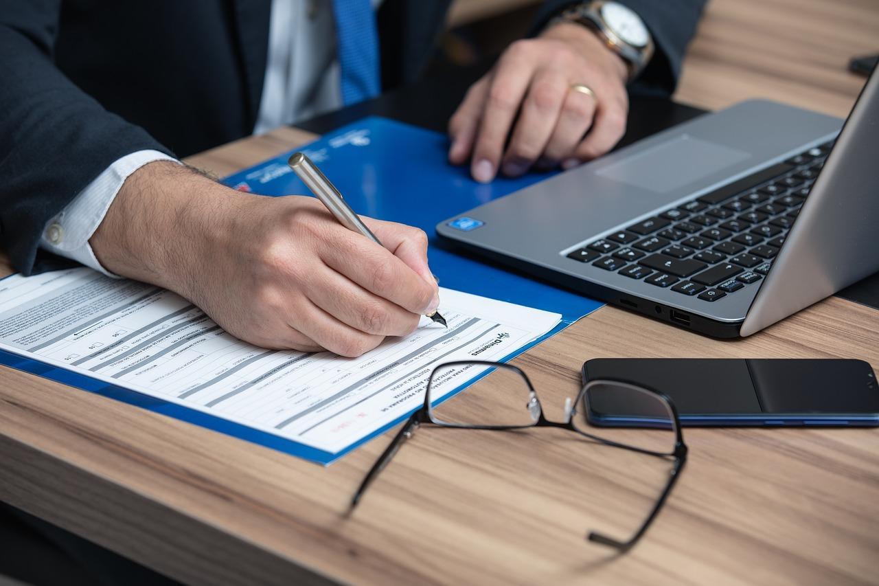 A lawyer completing a form at a desk, symbolizing legal assistance and documentation. This image relates to a Power of Attorney attorney in Alabama, highlighting the importance of legal guidance in granting authority to manage financial, medical, or personal matters.