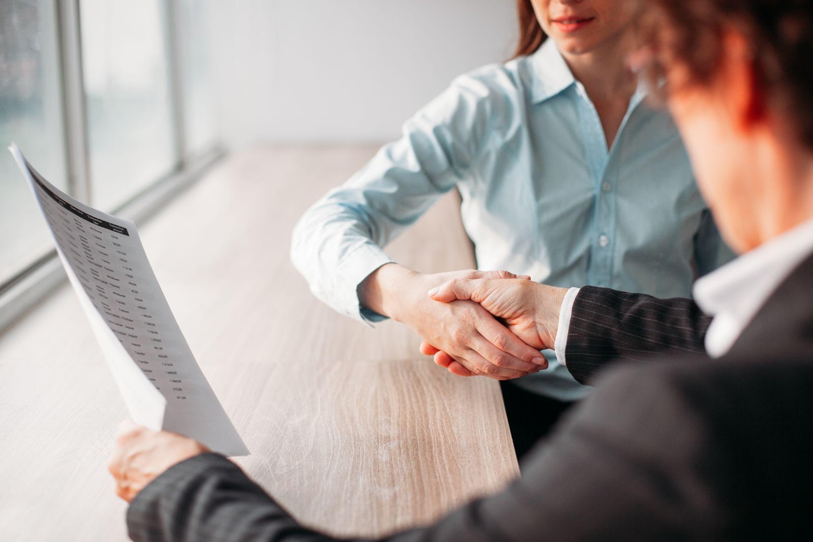 Two individuals shaking hands, symbolizing agreement and resolution. This image relates to settlement negotiations, emphasizing mediation and alternative dispute resolution as effective methods to resolve disputes without going to trial.