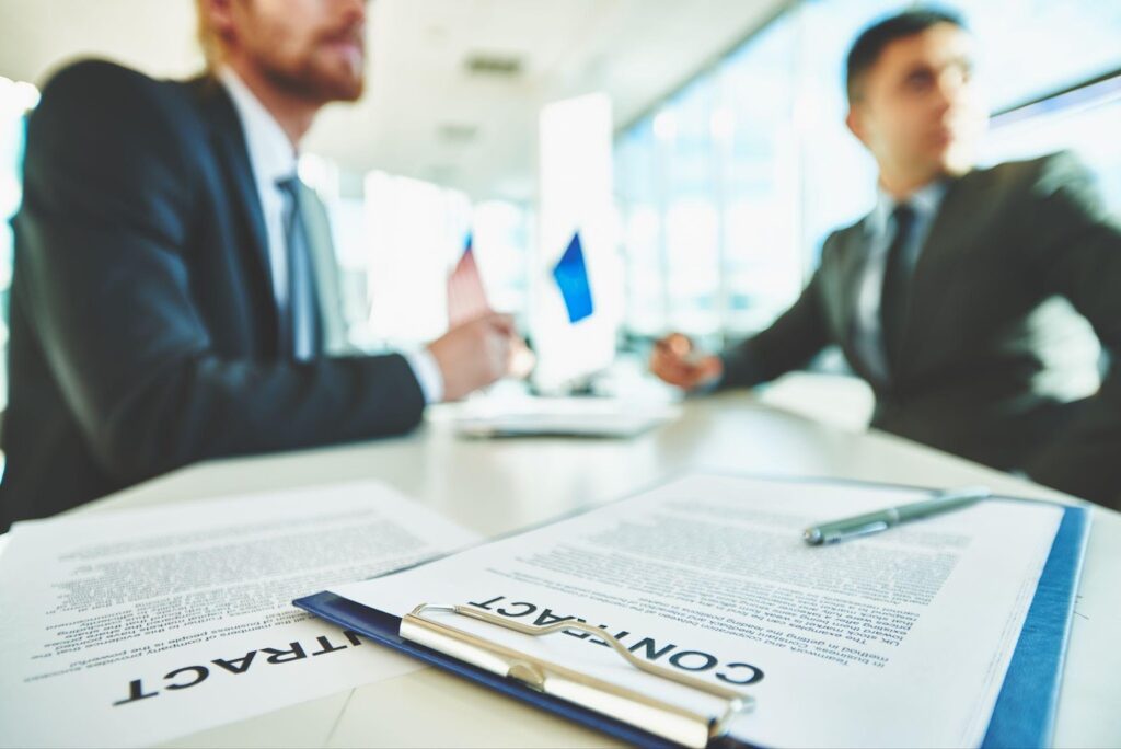 Two lawyers in a professional setting discussing documents, symbolizing collaboration and negotiation. This image relates to settlement negotiations, focusing on understanding settlement offers and counteroffers to reach a fair resolution in legal disputes.