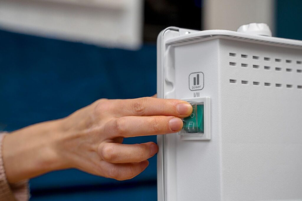 A close-up of a hand pressing a heater button, symbolizing control over heating systems. This image relates to carbon monoxide poisoning, emphasizing landlord responsibilities and tenant rights in ensuring safe living conditions and preventing harmful exposure.