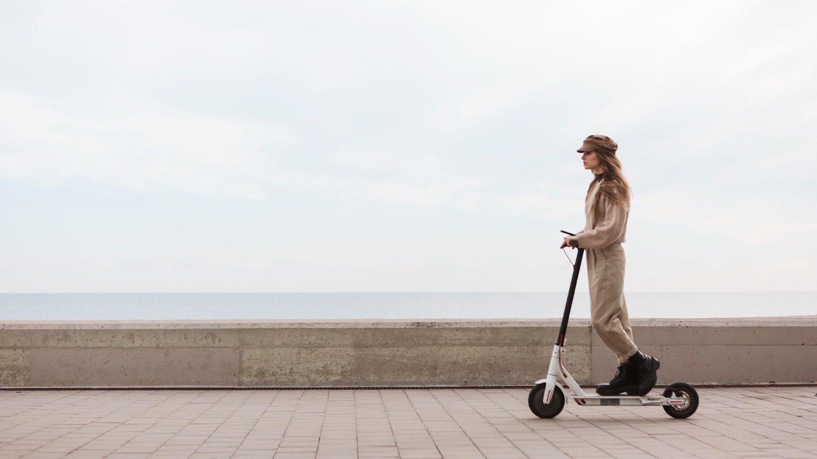 A young woman driving an electric scooter on a city street, symbolizing modern transportation. This image relates to electric scooter safety, highlighting best practices for riders and pedestrians to prevent accidents and ensure safe usage.