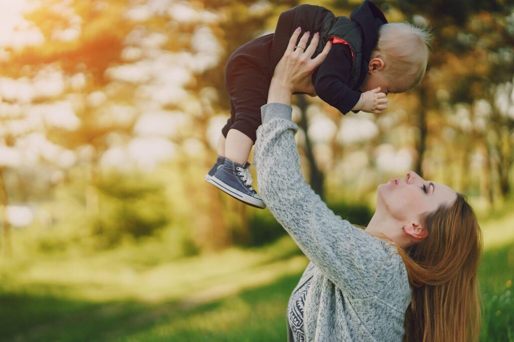 A mother playing with her child, smiling and sharing a joyful moment, while also highlighting FAQs about child custody in Alabama. The image reflects the nurturing relationship between a mother and child, with an emphasis on understanding child custody laws and processes in Alabama.