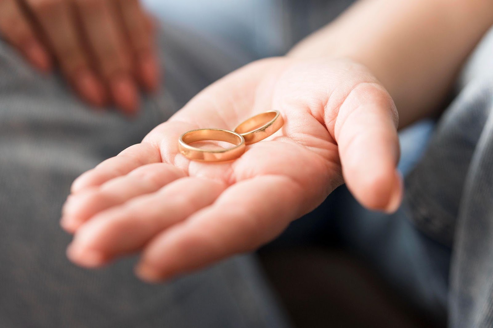 A close-up of a hand holding wedding rings, symbolizing the end of a marriage, with a focus on FAQs about divorce mediation in Alabama. The image highlights the emotional aspect of divorce while providing insight into the mediation process in Alabama.