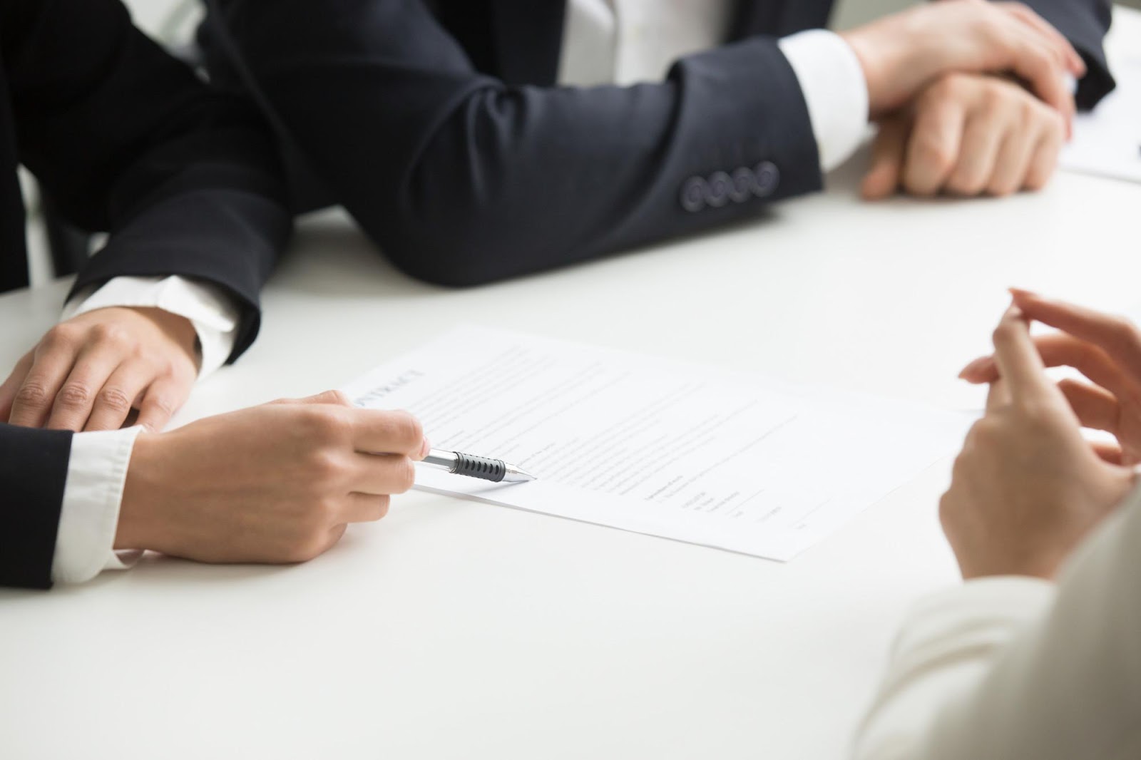 Lawyers and a client discussing a case at a table, symbolizing a formal meeting. This image relates to filing a complaint against an attorney for legal malpractice, highlighting the process of addressing professional misconduct or negligence.