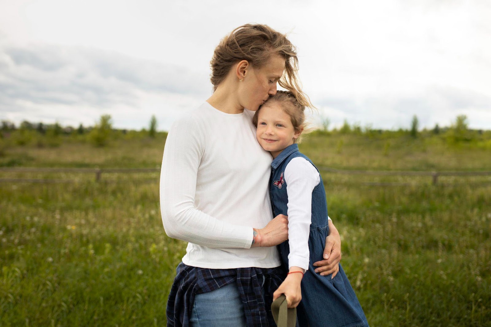 A parent hugging their child outdoors, symbolizing love and support. This image relates to tips for successful co-parenting in Alabama, emphasizing collaboration and nurturing relationships for the child's well-being.