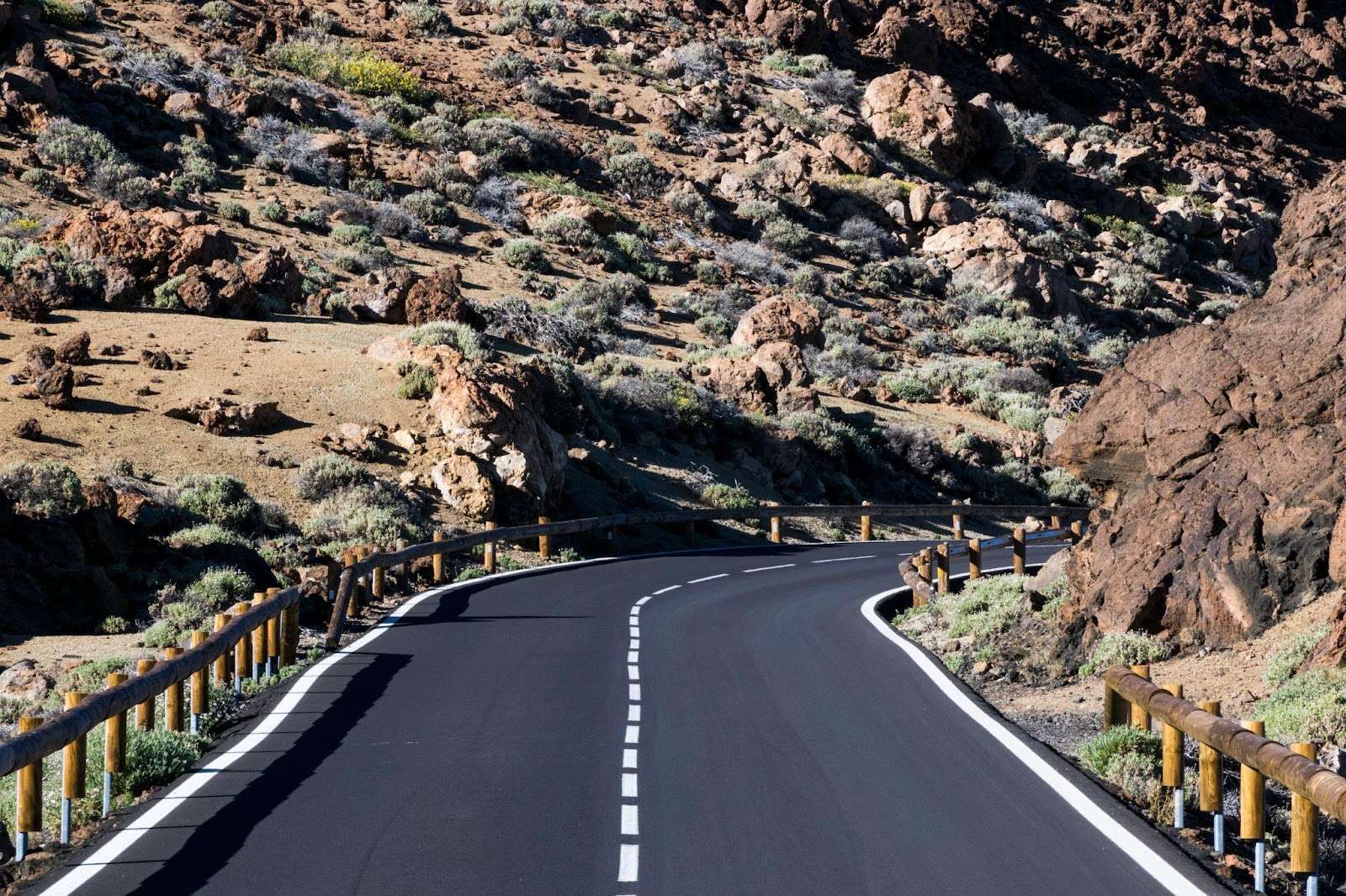 A winding road through a scenic, rocky landscape, with clear lane markings and sturdy guardrails along the sides. If you're a motorcyclist wondering is it legal to lane split in Alabama, understanding state traffic laws is essential for safe and compliant riding.