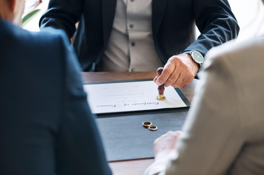 A lawyer assisting a couple as they sign papers, representing the legal separation process in Alabama.