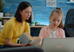 A parent and child sitting together at a table, focused on studying with books and papers in front of them. This scene reflects the adoption home study process, symbolizing the importance of a nurturing and supportive environment in preparing for adoption.