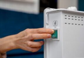 A close-up of a hand pressing a heater button, symbolizing control over heating systems. This image relates to carbon monoxide poisoning, emphasizing landlord responsibilities and tenant rights in ensuring safe living conditions and preventing harmful exposure.