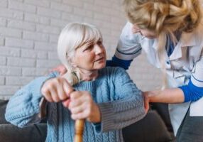 A caregiver assisting an elderly woman, highlighting concerns about elder abuse, including nursing home neglect and financial exploitation, which are serious issues affecting vulnerable seniors in Alabama.