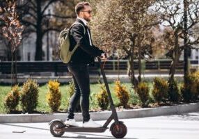 A person riding an electric scooter on a city street, symbolizing urban mobility. This image relates to electric scooter accidents, focusing on rental programs and the process of filing injury claims in case of accidents.