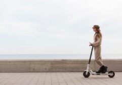 A young woman driving an electric scooter on a city street, symbolizing modern transportation. This image relates to electric scooter safety, highlighting best practices for riders and pedestrians to prevent accidents and ensure safe usage.