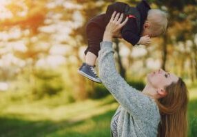 A mother playing with her child, smiling and sharing a joyful moment, while also highlighting FAQs about child custody in Alabama. The image reflects the nurturing relationship between a mother and child, with an emphasis on understanding child custody laws and processes in Alabama.