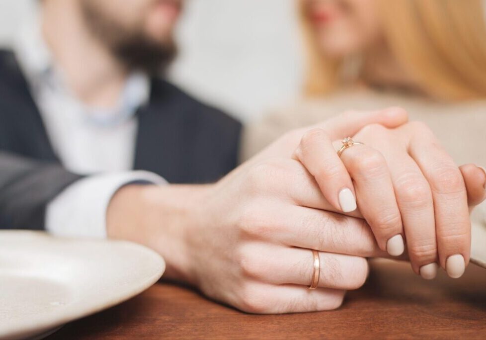 A close-up of a married couple's hands, wearing wedding rings, gently touching. The image relates to FAQs about prenuptial agreements in Alabama, symbolizing marriage and legal planning.