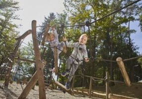 Two children playing on a playground, symbolizing activity and enjoyment. This image relates to playground injuries, highlighting issues of negligence, maintenance, and liability in ensuring a safe environment for children.