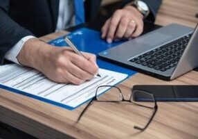 A lawyer completing a form at a desk, symbolizing legal assistance and documentation. This image relates to a Power of Attorney attorney in Alabama, highlighting the importance of legal guidance in granting authority to manage financial, medical, or personal matters.