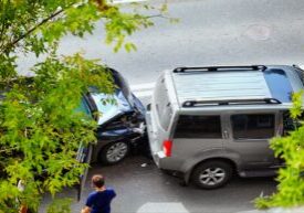 Two cars involved in a rear-end collision on a street.