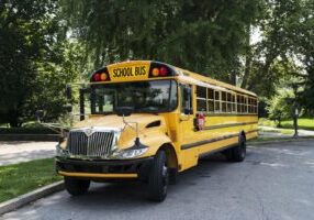 A yellow school bus parked on the roadside, symbolizing student transportation. This image relates to school bus accidents, highlighting issues of liability and the importance of ensuring student safety during transit.