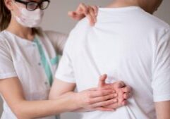 A woman wearing a mask and checking a patient, symbolizing medical care and rehabilitation. This image relates to spinal cord injuries, emphasizing rehabilitation, adaptive equipment, and lifestyle changes for improving quality of life.