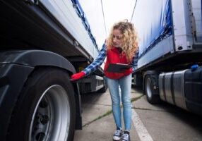 Person inspecting a truck for safety and maintenance to ensure it's roadworthy and compliant with regulations.