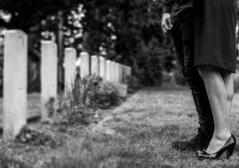 A grieving couple stands together in a cemetery, holding each other for support. The image reflects the emotional impact of wrongful death claims, highlighting the pursuit of justice and accountability for a loved one's loss due to negligence.